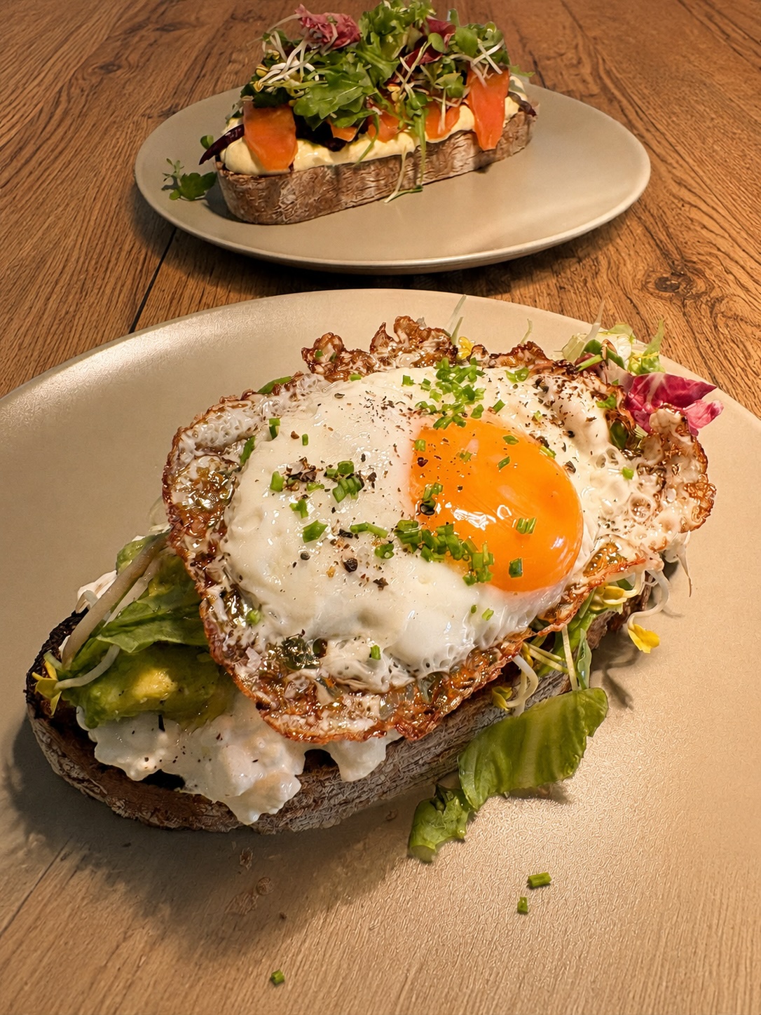 Stulle mit Avocado, körnigem Frischkäse und Spiegelei sowie Stulle Nordisch mit Lachs im Hintergrund